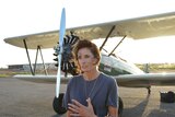 Adventurer Tracey Curtis-Taylor standing in front of 1940s-era biplane.