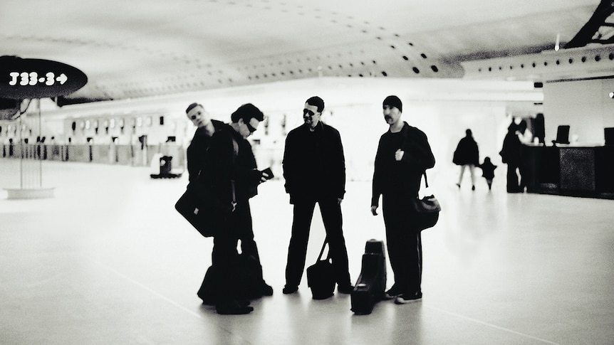 Black and white picture of U2 at an airport from the cover of 2000's All That You Can't Leave Behind