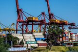 Cranes towering over storage containers at Port Botany.