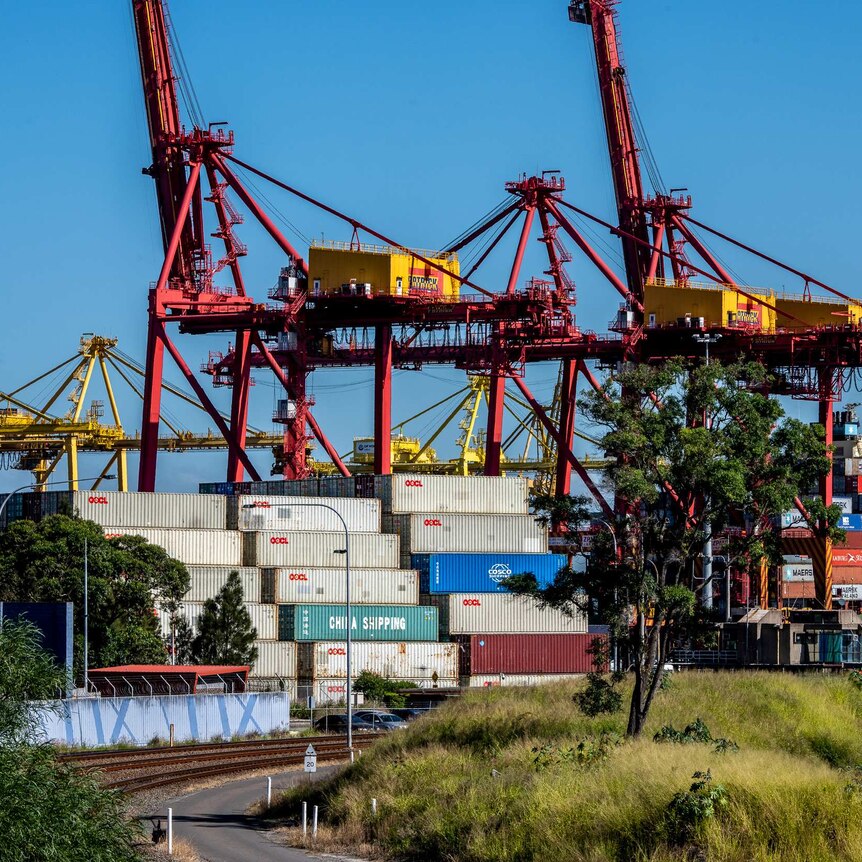 Cranes towering over storage containers at Port Botany.
