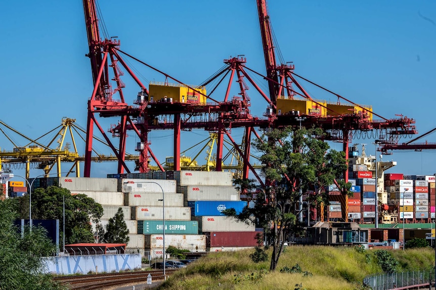 Cranes towering over storage containers at Port Botany.