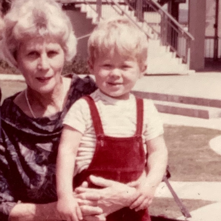 Old photo of elderly woman and little boy in red overalls