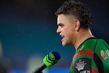 South Sydney Rabbitohs' Latrell Mitchell, seen from the side, speaks into a Fox Sports microphone after an NRL game.