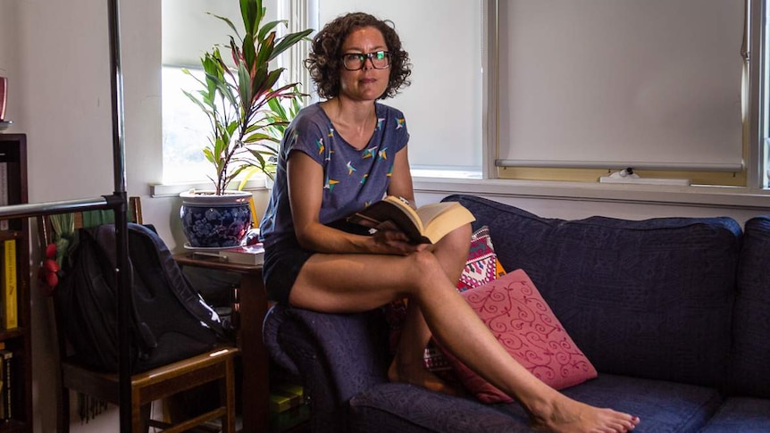 Melanie Burge sits on the couch.