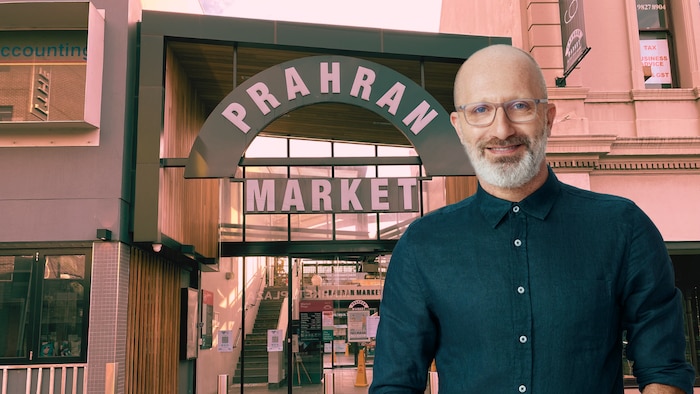 Raf Epstein against a background with a signage stating Prahran Market
