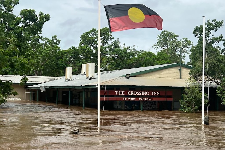 The Crossing Inn pub in Fitzroy Crossing surrounded by floodwaters, with the water level almost up to the roof.