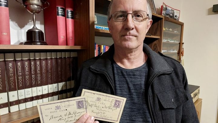 Gladstone historian, Steve Schultz, holding postcards from 1893 that he found on eBay.  