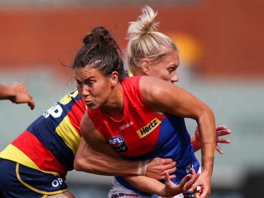 Два игрока AFLW сталкиваются в борьбе за мяч.