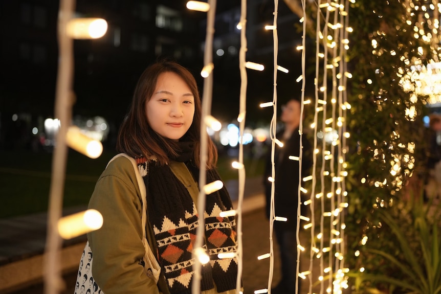 A woman standing among some lightening chains 