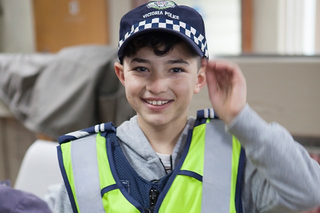 A young boy wears a police uniform