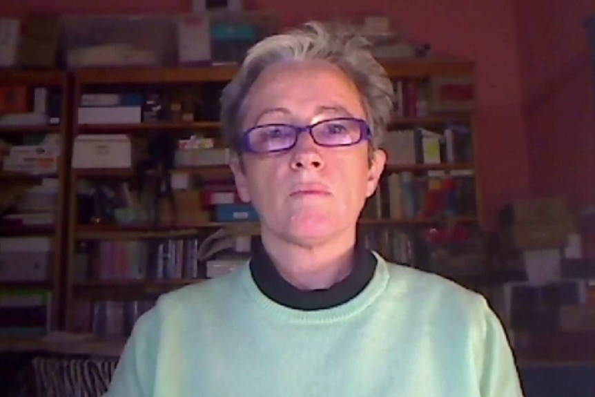 a woman sitting in front of a bookcase