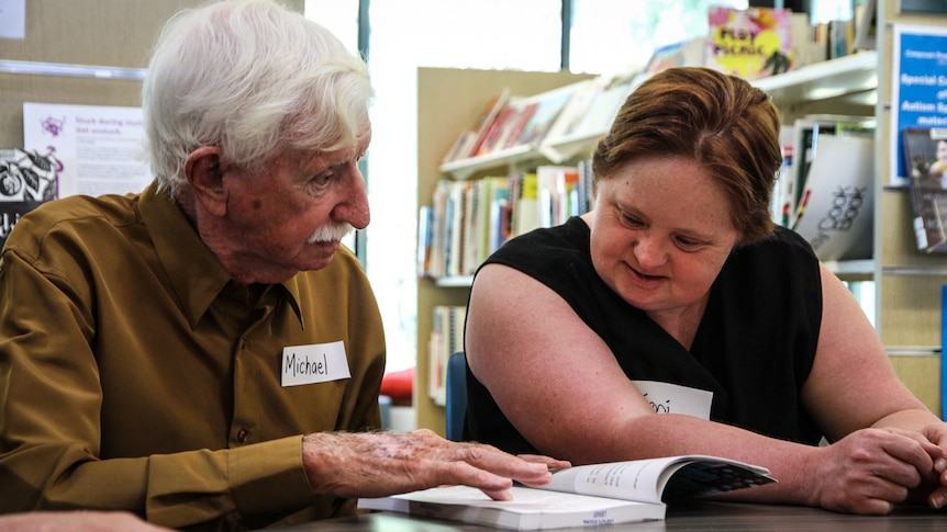 Volunteer Michael and Collingwood supporter Toni (right) who loves reading about football.