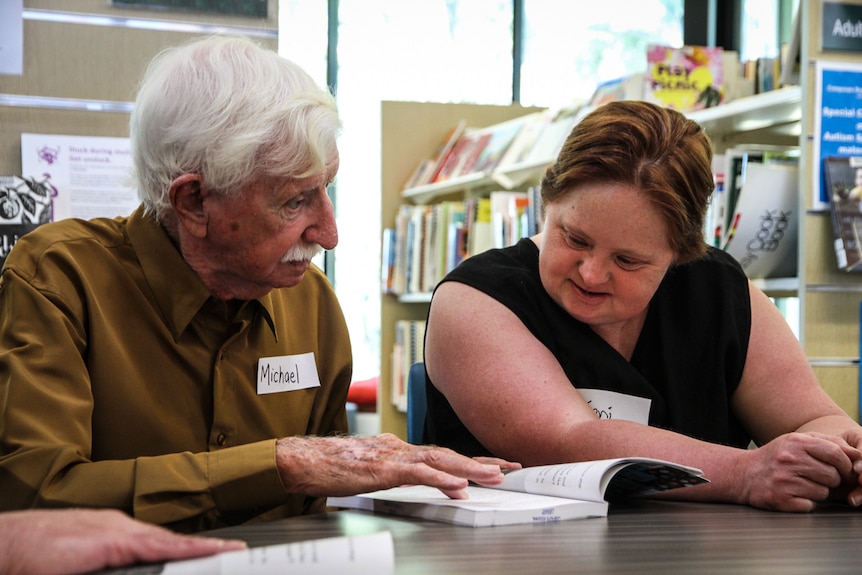 Volunteer Michael and Collingwood supporter Toni (right) who loves reading about football.