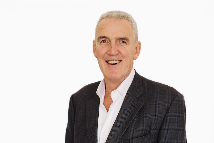 Great haired man wearing a white shirt and black jacket. 