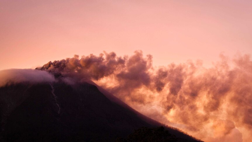 Smoke from the erupting Sinabung volcano is seen from Berastepu village on November 24, 2013.