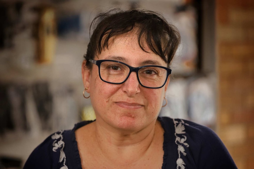 MCU of Narrabri businesswoman and councillor Ann Loder wearing wide black-rimmed glasses and a dark blue jumper