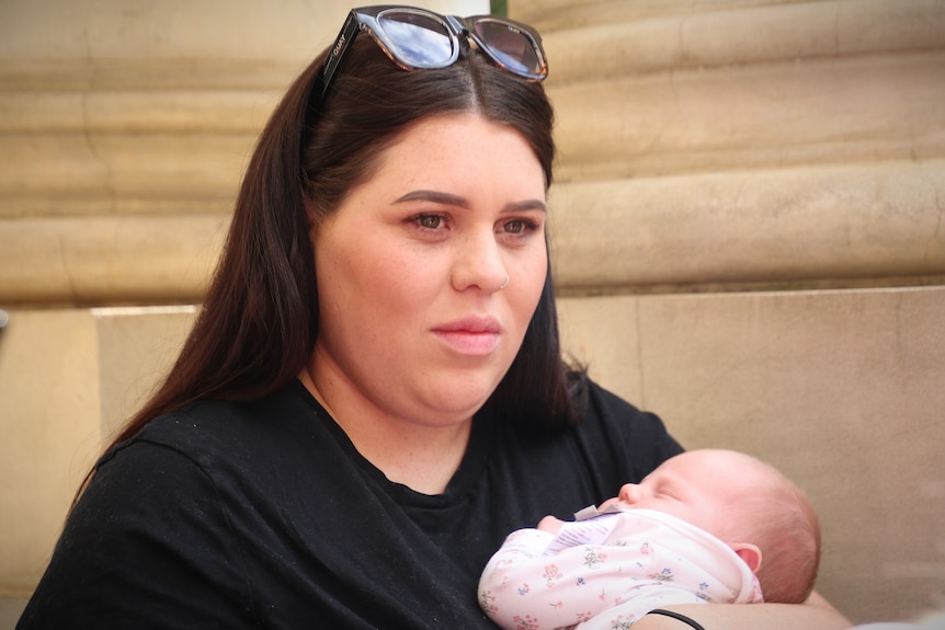 A young woman wearing a black shirt with sunglasses on her head