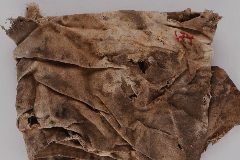 An old, dirty rag with writing embroidered on it