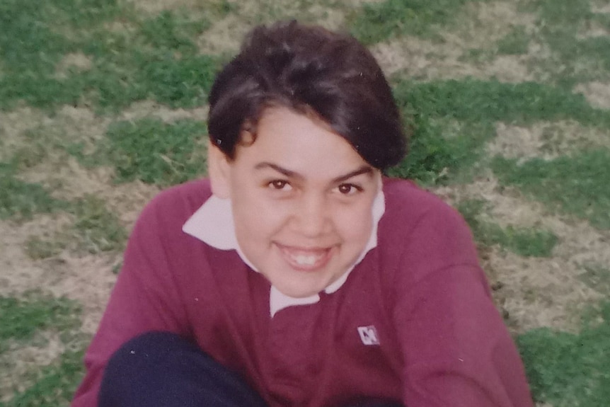 A boy smiles at the camera.