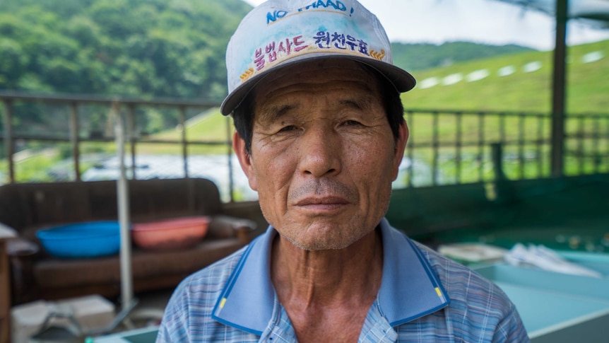 The village chief of Seongju stands front-on the camera, expressionless.