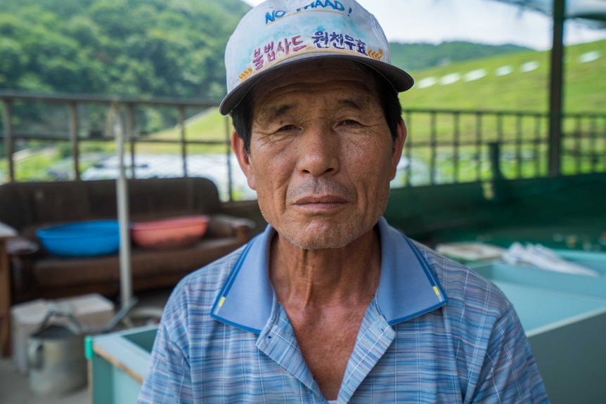 The village chief of Seongju stands front-on the camera, expressionless.