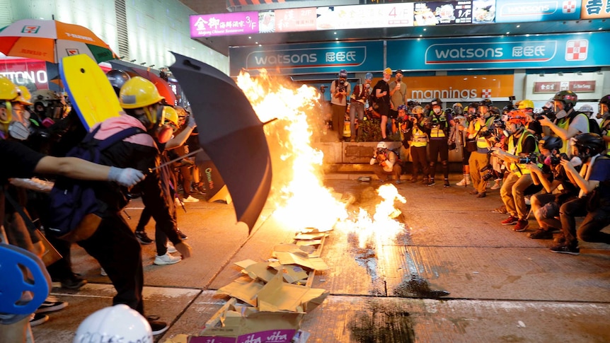 Protesters burn cardboard to form a barrier as they confront with police.