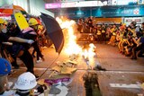 Protesters burn cardboard to form a barrier as they confront with police.