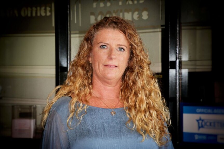 Ms Knight stands in front of the theatre doors.