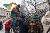 People in Lviv, weave materials netting to make a camouflage net.