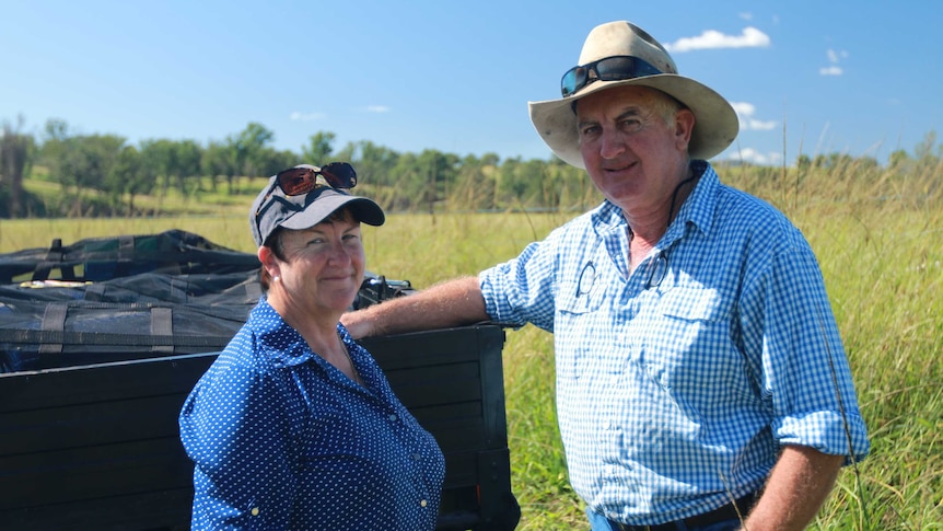 A man and a woman standing on a farm