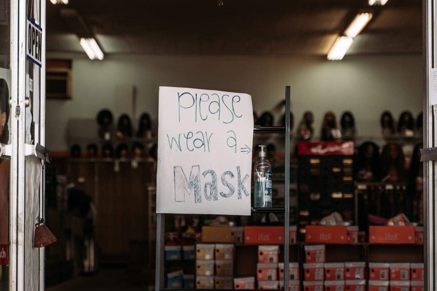 A shoe shop with a 'please wear a mask' sign out the front