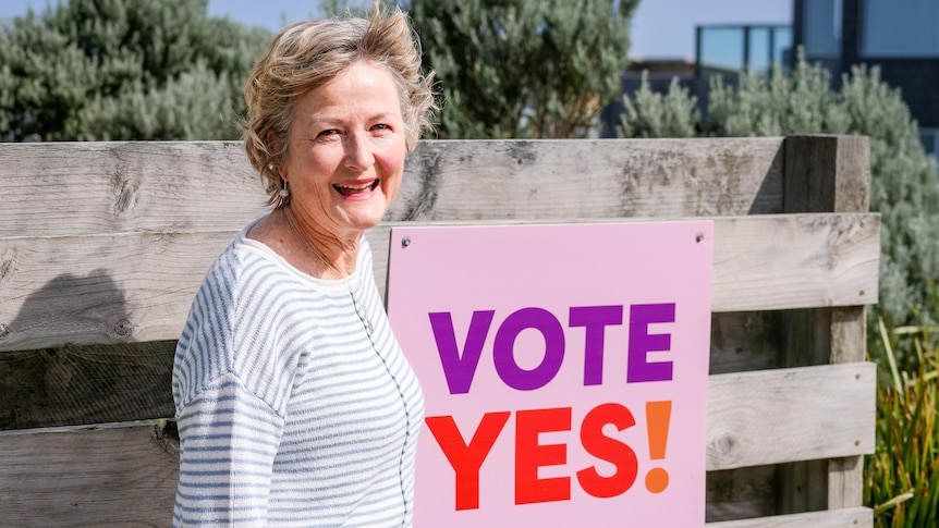 Monica Sammon stands near her yes sign