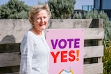 Monica Sammon stands near her yes sign