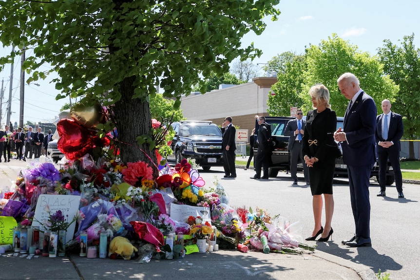 A woman and a man pay their respects at a memorial for a mass-shooting.