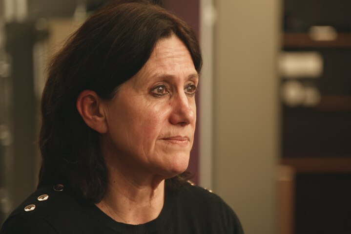 Profile image of a woman in black shirt in office