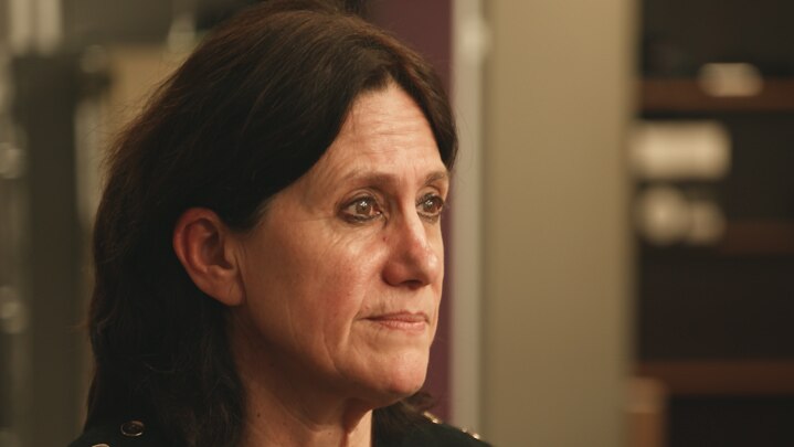 Profile image of a woman in black shirt in office