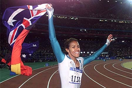Cathy Freeman carries flags during a victory lap after at the Sydney Games.