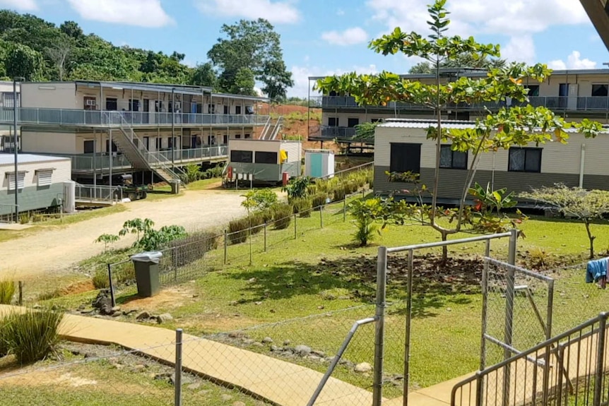 Accommodation facilities for refugees on Manus Island. They appear to be two-story portable buildings. There is a small garden.