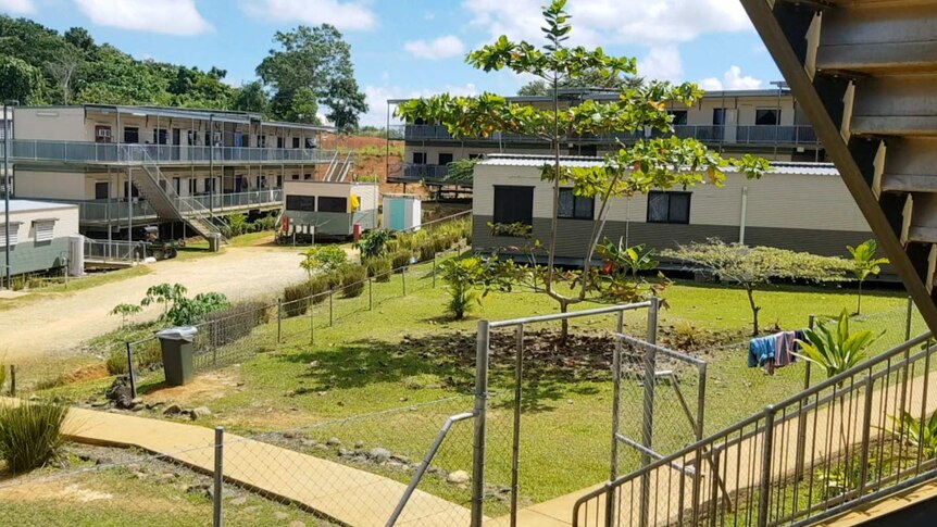 Accommodation facilities for refugees on Manus Island. They appear to be two-story portable buildings. There is a small garden.