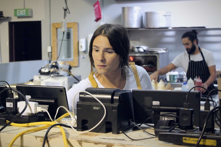 Two chefs work inside a commercial kitchen