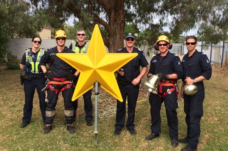 Victorian police officers with the Christmas star retrieved from on high.