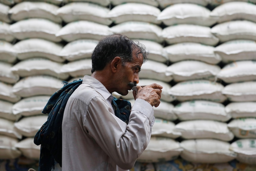 A labourer drinks tea from a saucer.