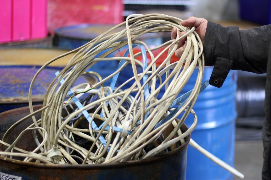 A tangle of old computer cables in a petrol drum