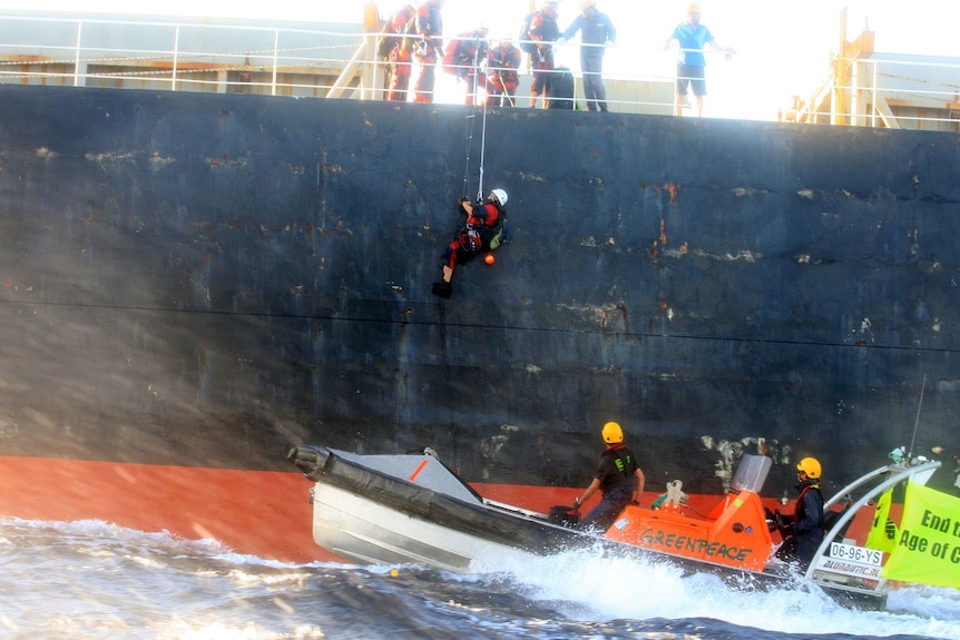 Greenpeace activists climb aboard the ship