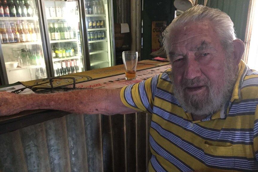82yo Grove Hill hotel publican Stan Heausler sits at the bar with a drink in front of him