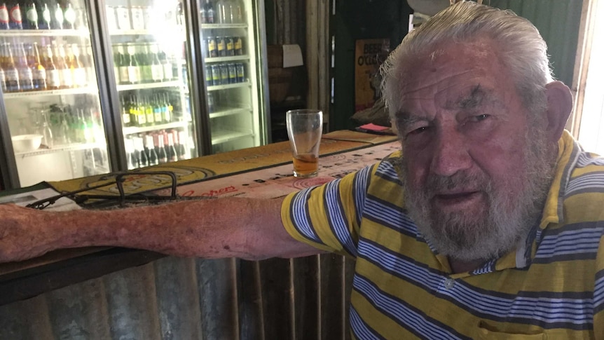 83yo Grove Hill hotel publican Stan Heausler sits at the bar with a drink in front of him