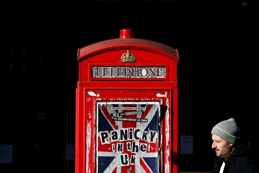 A London telephone box with a poster reading "panicky in the UK"