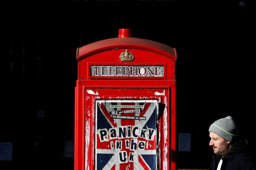 A London telephone box with a poster reading "panicky in the UK"