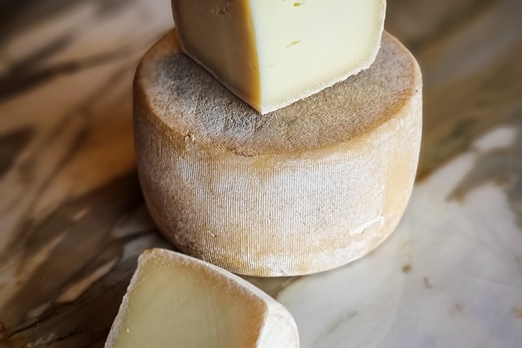 De grandes meules de fromage sur une planche à découper.
