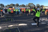 High-vis clad workers do yoga.